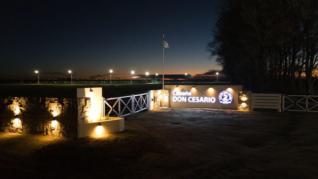 Entrada de Cabaña Don Cesario, con cartel, de noche